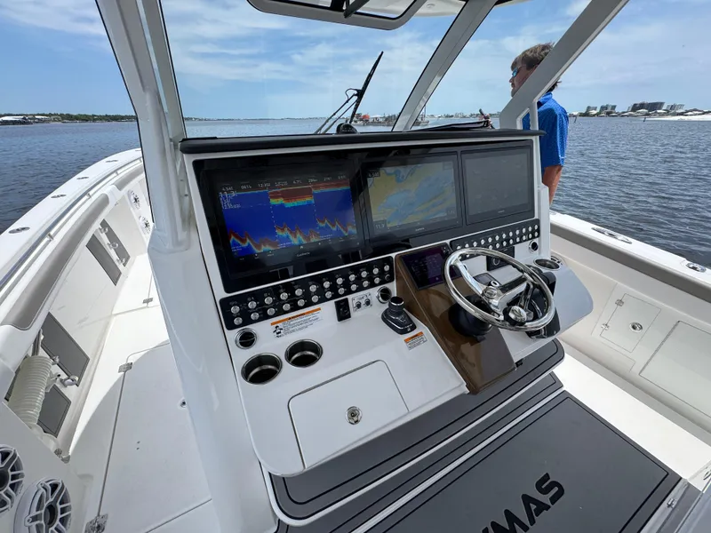 Slide: The Image of 2026 Caymas 44 CT boat dashboard with advanced navigation screens and controls on open water. - 35