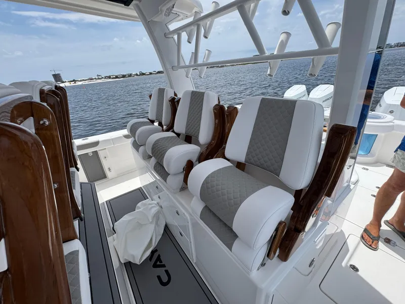 Slide: The Image of 2026 Caymas 44 CT boat interior with luxurious seating and rod holders, overlooking a serene water view. - 38