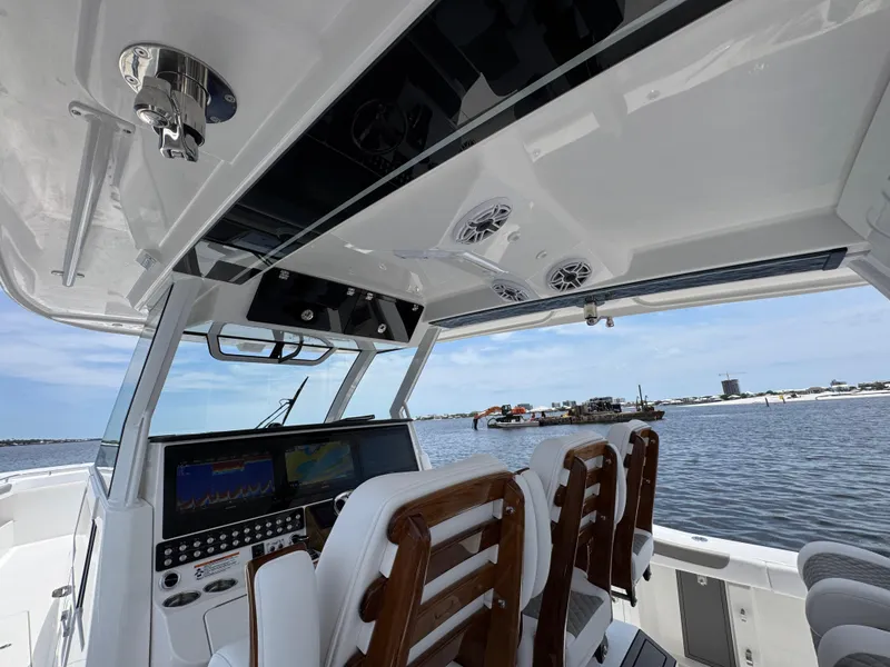 Slide: The Image of 2026 Caymas 44 CT boat interior with advanced navigation system and wooden seating, overlooking a serene waterfront. - 39