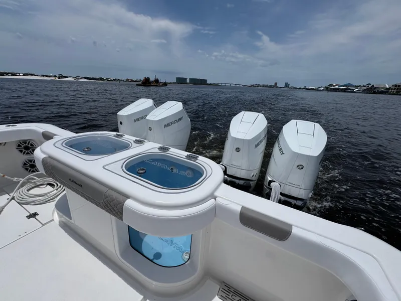 Slide: The Image of 2026 Caymas 44 CT boat with four Mercury outboard engines on a calm waterway. - 48