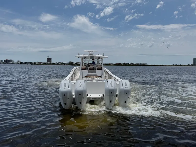 Slide: The Image of 2026 Caymas 44 CT boat with multiple engines cruising on a sunny day. - 7