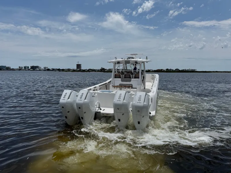 Slide: The Image of 2026 Caymas 44 CT boat with multiple engines cruising on a calm waterway. - 8