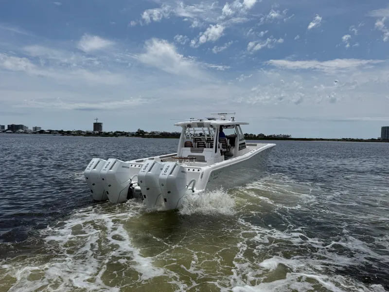 Slide: The Image of 2026 Caymas 44 CT boat cruising on open water under a partly cloudy sky. - 9