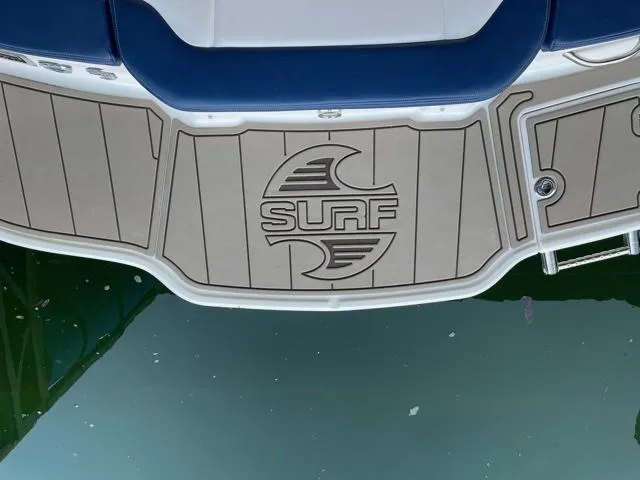 Slide: The Image of 2020 Chaparral 21 Surf boat deck with logo, floating on water. - 14