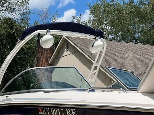 Slide: The Image of 2020 Chaparral 21 Surf boat with wakeboard tower, docked near a house. - 28