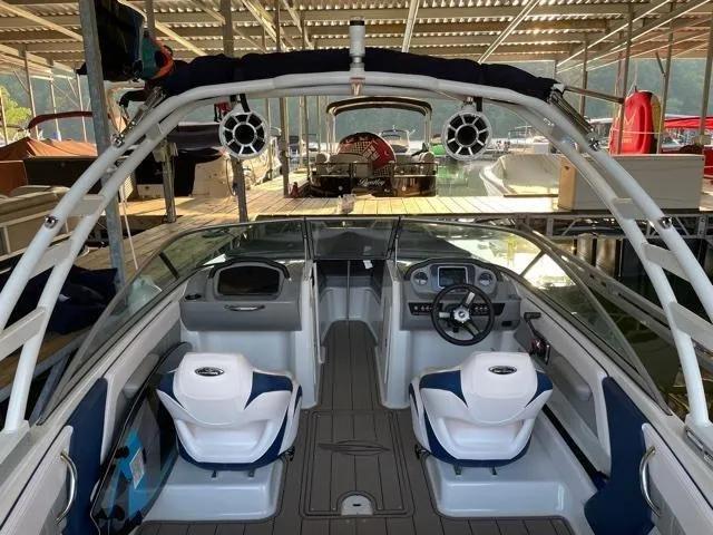 Slide: The Image of 2020 Chaparral 21 Surf boat interior with dual seats and steering wheel in a marina. - 9