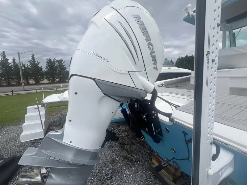 Slide: The Image of 2023 Everglades 253 CC boat with Mercury outboard motor, parked on gravel. - 10