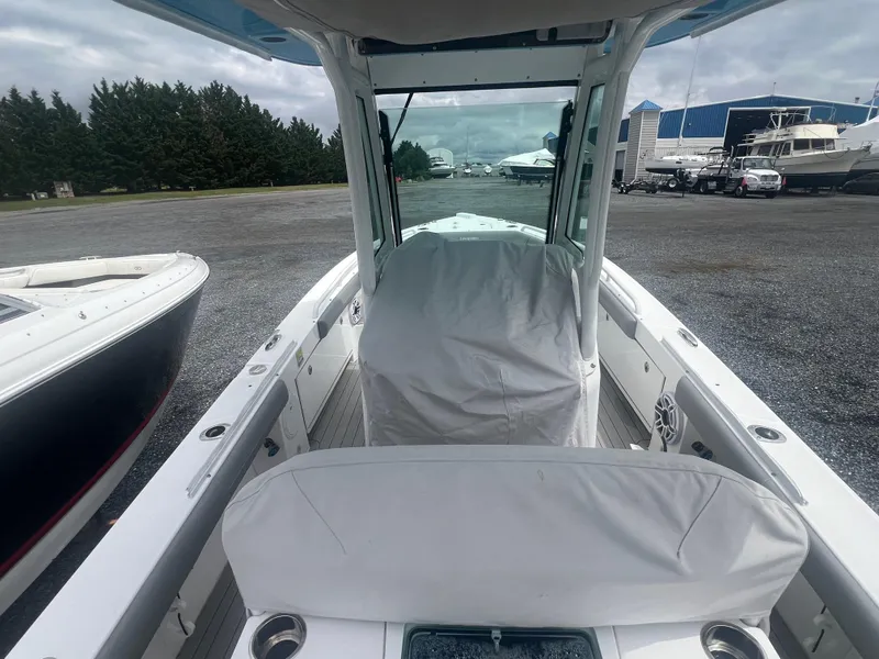 Slide: The Image of 2023 Everglades 253 CC boat with covered console, docked outdoors. - 12