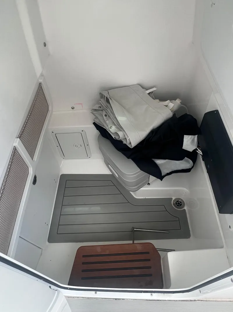 Slide: The Image of 2023 Everglades 253 CC boat interior storage area with folded gear and equipment. - 15