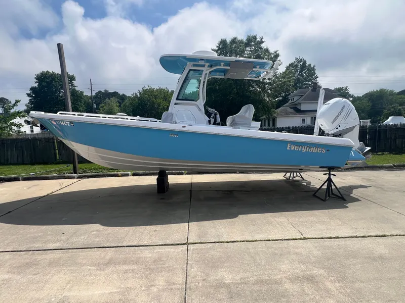 Slide: The Image of 2023 Everglades 253 CC boat in light blue, parked on a concrete driveway. - 2