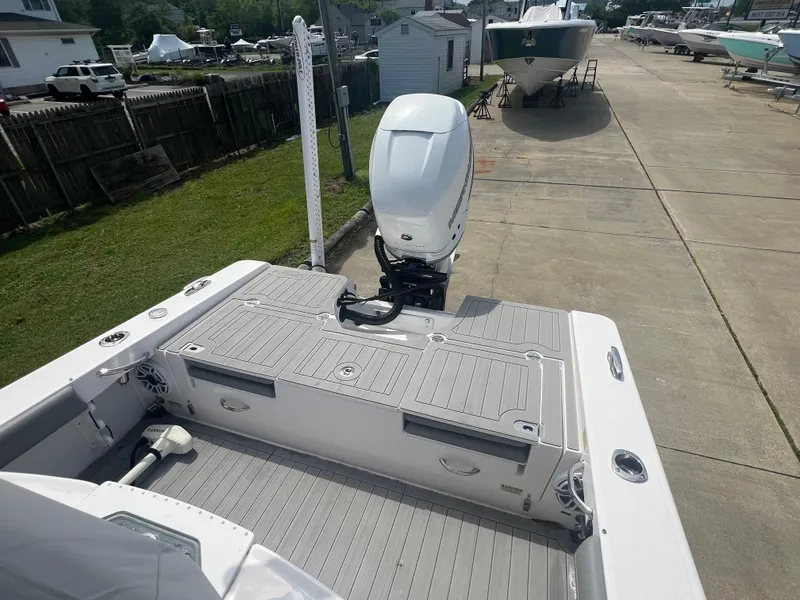 Slide: The Image of 2023 Everglades 253 CC boat with outboard motor, docked on a sunny day. - 7