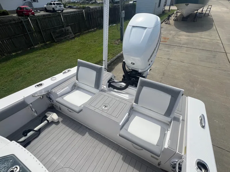 Slide: The Image of 2023 Everglades 253 CC boat with dual seating and outboard motor in a driveway. - 8