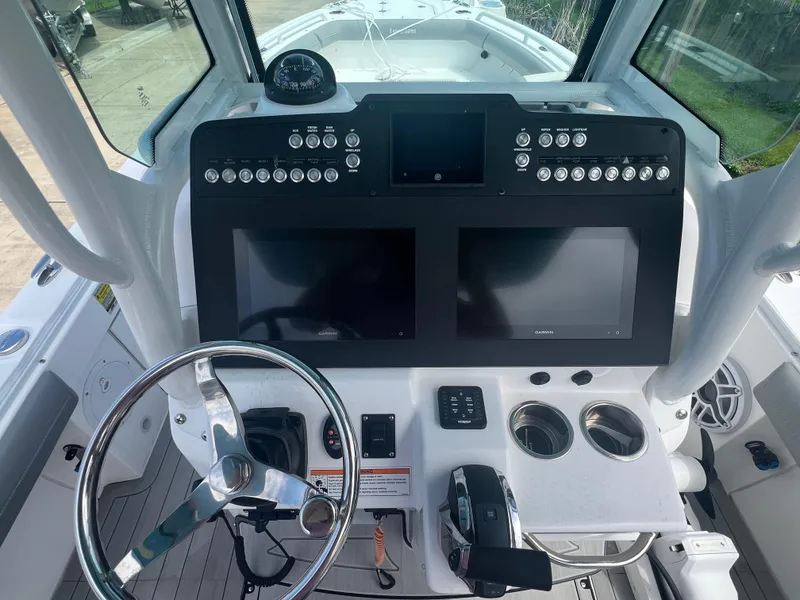 Slide: The Image of 2023 Everglades 253 CC boat dashboard with dual screens and steering wheel. - 9
