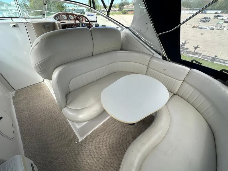 Slide: The Image of 2002 Four Winns 268 Vista boat interior with curved seating and table. - 14