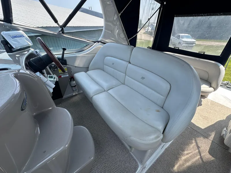 Slide: The Image of 2002 Four Winns 268 Vista boat interior with white seating and steering area. - 17