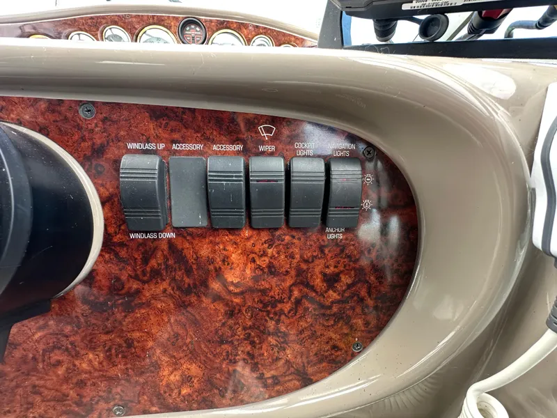 Slide: The Image of Control panel of a 2002 Four Winns 268 Vista boat with switches and woodgrain finish. - 22
