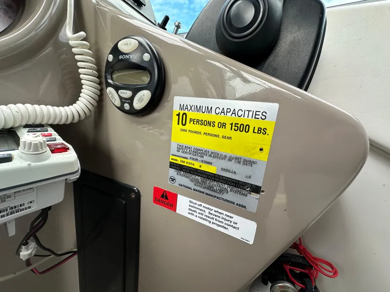 Slide: The Image of 2002 Four Winns 268 Vista boat dashboard with capacity label for 10 persons or 1500 lbs. - 24
