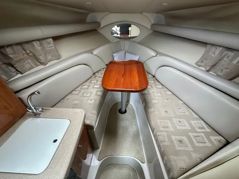 Slide: The Image of 2002 Four Winns 268 Vista cabin interior with seating, table, and sink. - 27