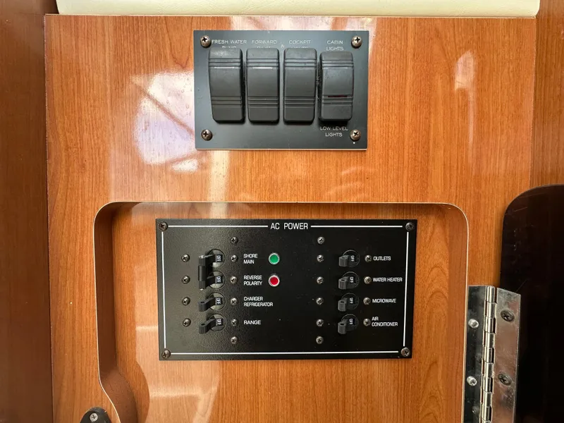 Slide: The Image of Control panel on a 2002 Four Winns 268 Vista boat, featuring AC power switches. - 30