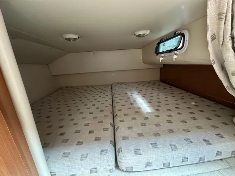 Slide: The Image of 2002 Four Winns 268 Vista cabin interior with twin beds and small window. - 32