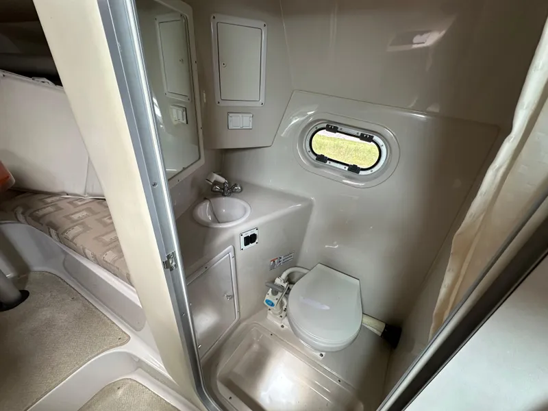 Slide: The Image of 2002 Four Winns 268 Vista boat interior bathroom with sink, toilet, and porthole window. - 33