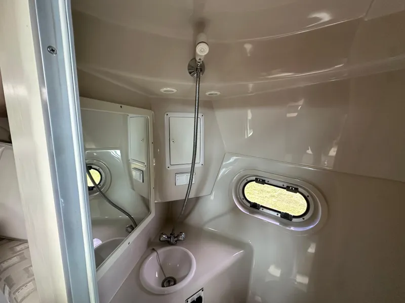 Slide: The Image of 2002 Four Winns 268 Vista boat bathroom with sink, mirror, and porthole window. - 34