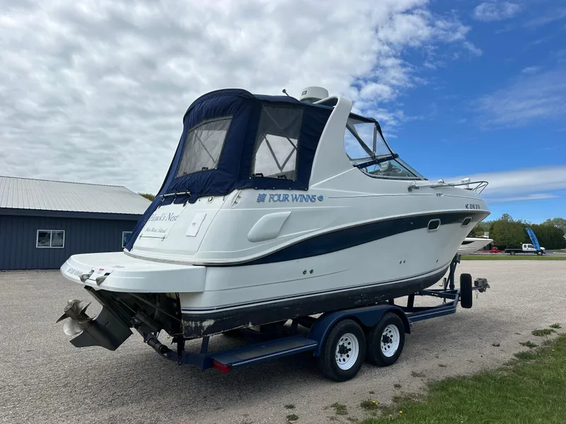 Slide: The Image of 2002 Four Winns 268 Vista boat on trailer, parked outdoors under cloudy sky. - 4