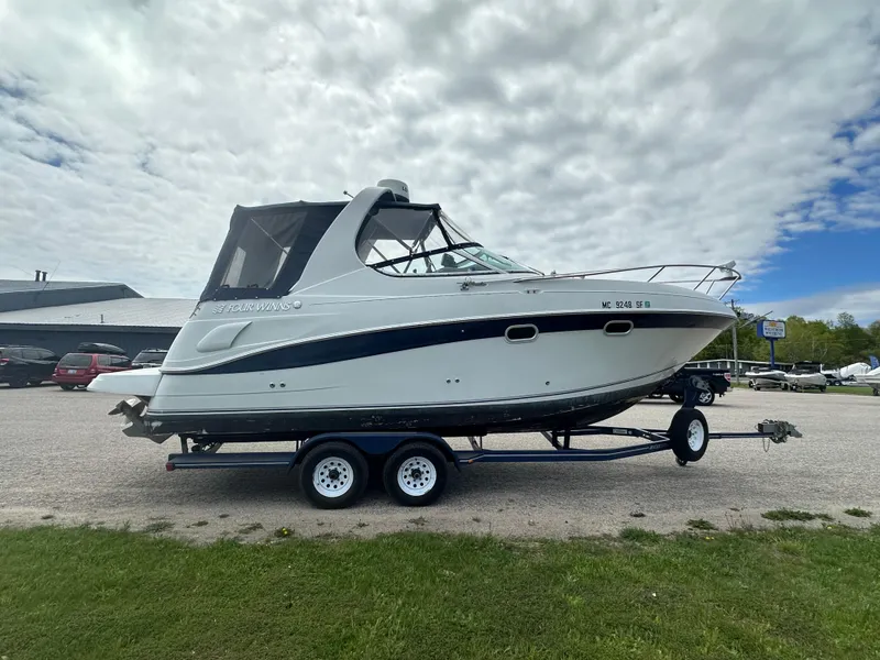 Slide: The Image of 2002 Four Winns 268 Vista boat on trailer, parked outdoors under cloudy sky. - 5