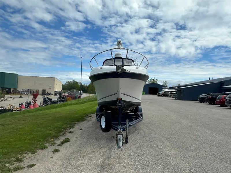 Slide: The Image of 2002 Four Winns 268 Vista boat on trailer, parked outdoors under cloudy sky. - 7