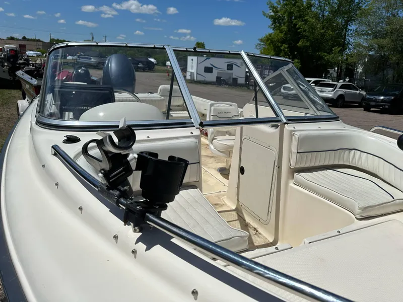 Slide: The Image of 2003 Sea Hunt Escape 186 boat with open seating and windshield, parked outdoors under blue sky. - 10