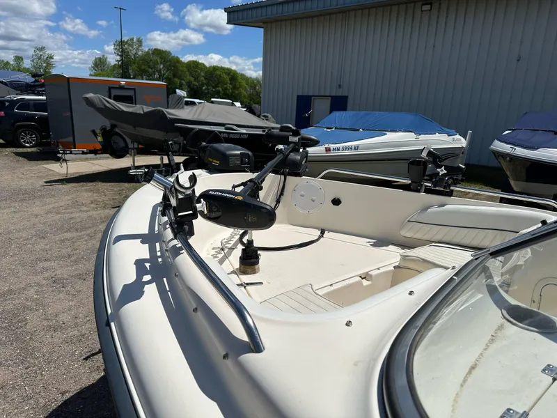 Slide: The Image of 2003 Sea Hunt Escape 186 boat parked outdoors, featuring a trolling motor and clear skies. - 11