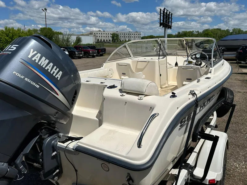 Slide: The Image of 2003 Sea Hunt Escape 186 boat with Yamaha 115 engine, parked outdoors under a blue sky. - 14
