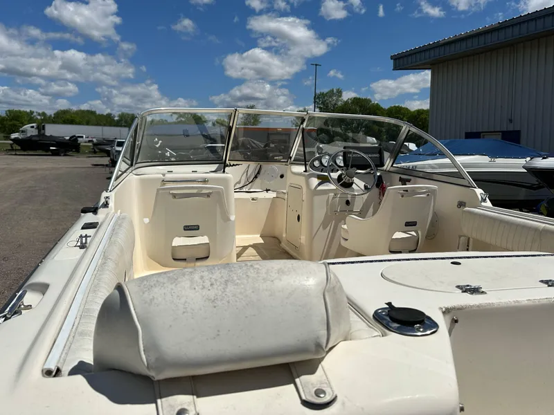 Slide: The Image of 2003 Sea Hunt Escape 186 boat with open deck, parked outdoors under a blue sky. - 15