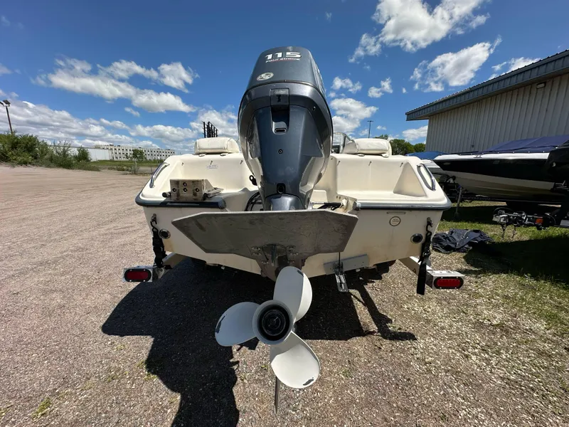 Slide: The Image of 2003 Sea Hunt Escape 186 boat with outboard motor, parked on gravel under a blue sky. - 4
