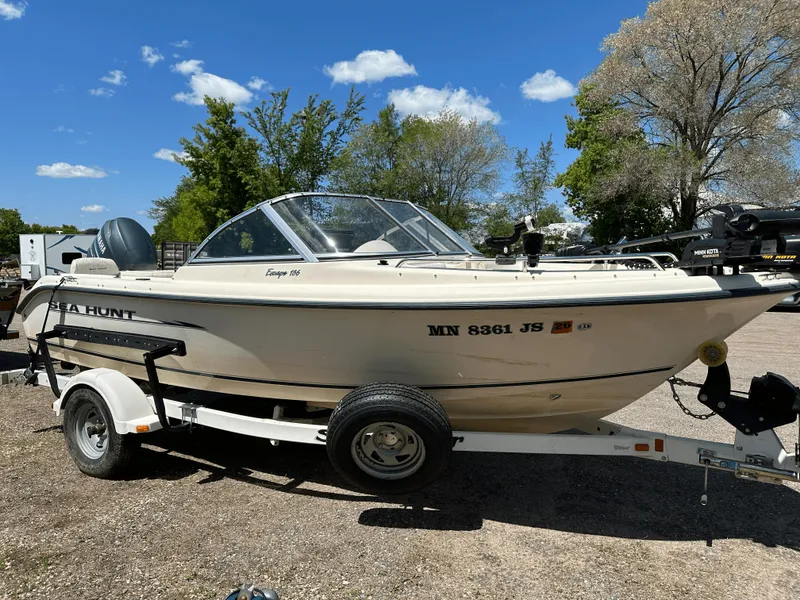 Slide: The Image of 2003 Sea Hunt Escape 186 boat on trailer, parked outdoors under clear blue sky. - 5