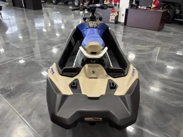 Slide: The Image of 2025 Sea-Doo Spark Trixx Waverunner, blue and beige, displayed indoors on polished floor. - 10