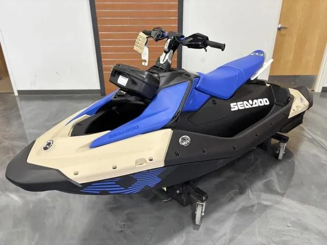 Slide: The Image of 2025 Sea-Doo Waverunner Spark Trixx, blue and beige, displayed indoors. - 4