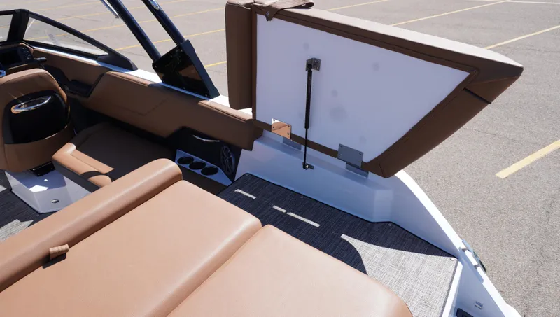 Slide: The Image of 2024 Cobalt CS23 boat interior with brown seating and open storage compartment. - 11
