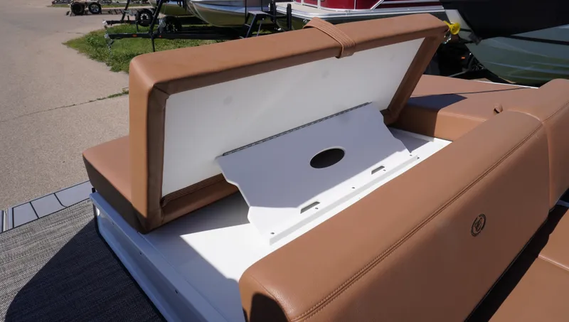 Slide: The Image of 2024 Cobalt CS23 boat with open storage compartment, brown seating, and white interior. - 13