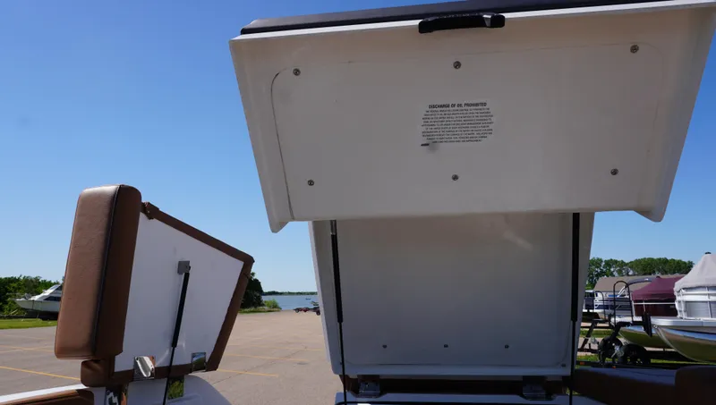 Slide: The Image of 2024 Cobalt CS23 boat storage compartment open, showcasing spacious interior under clear blue sky. - 17