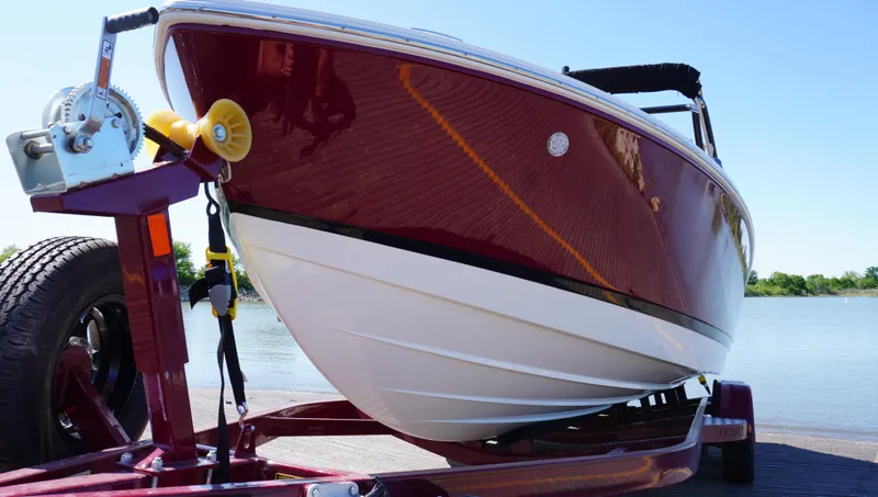 Slide: The Image of 2024 Cobalt CS23 boat on trailer by the water, showcasing sleek red and white design. - 6
