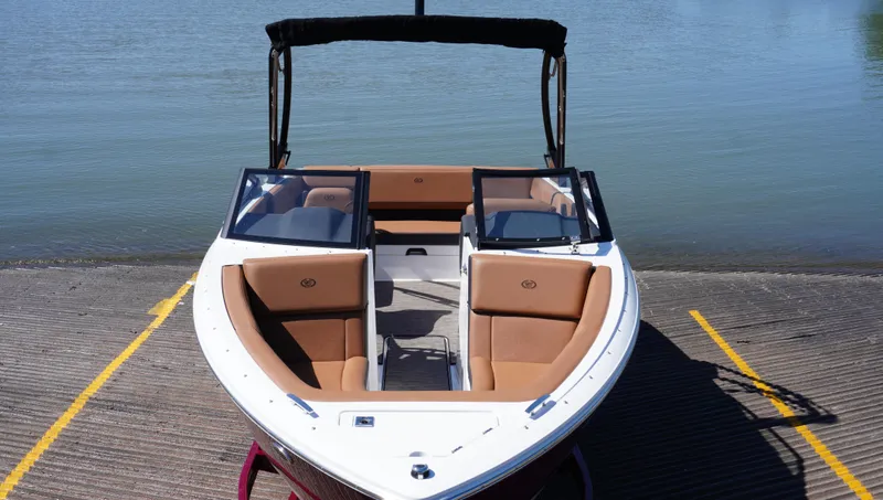 Slide: The Image of 2024 Cobalt CS23 boat with tan seating, docked by calm water. - 8