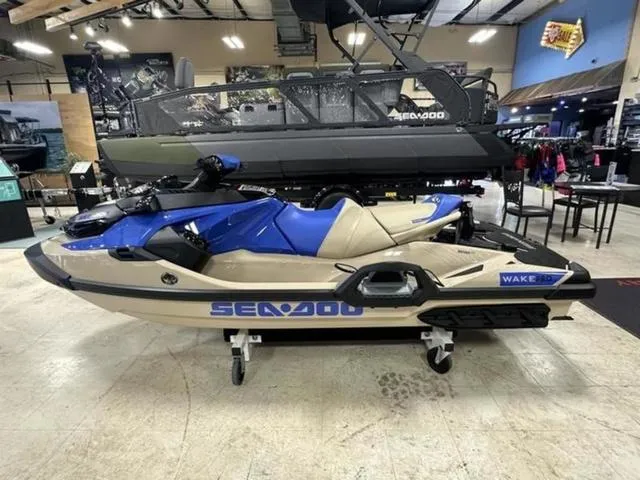 Slide: The Image of 2025 Sea-Doo Waverunner Wake in showroom, blue and beige design, side view. - 5