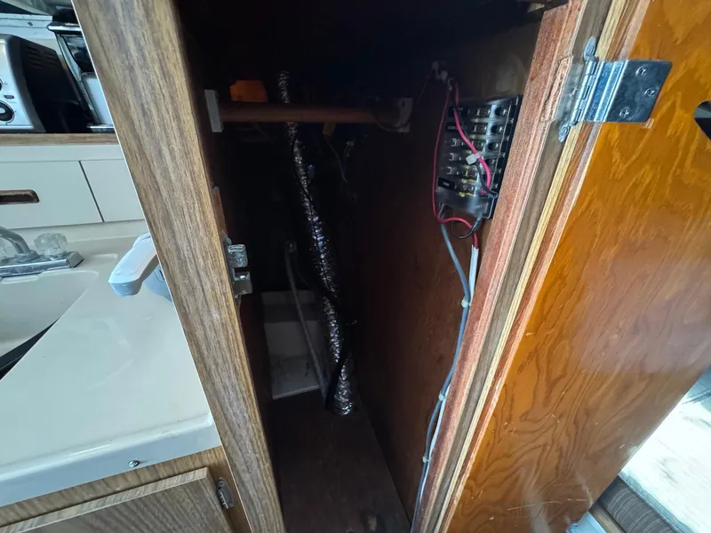 Slide: The Image of 1973 Bertram 28 Sport Fisherman interior cabinet with wiring and electrical panel. - 11