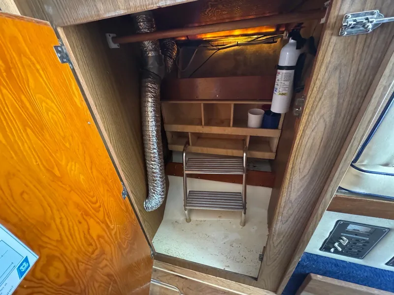Slide: The Image of 1973 Bertram 28 Sport Fisherman interior storage with fire extinguisher and ventilation duct. - 12