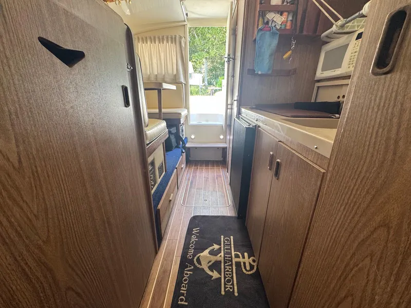 Slide: The Image of Interior of a 1973 Bertram 28 Sport Fisherman boat with wood paneling and compact kitchen. - 13