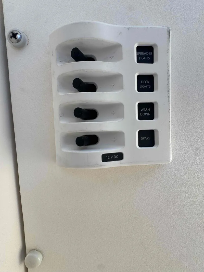 Slide: The Image of 1973 Bertram 28 Sport Fisherman control panel with switches for lights and washdown. - 25