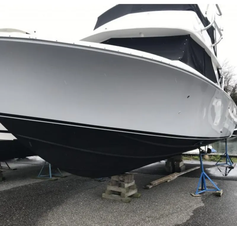 Slide: The Image of 1973 Bertram 28 Sport Fisherman boat on stands, white hull, black bottom. - 4