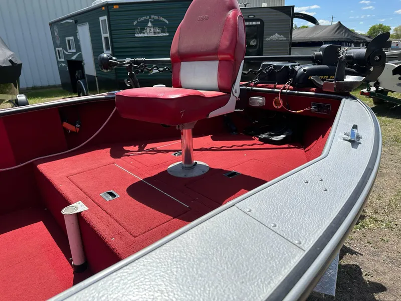 Slide: The Image of 1995 Lund 1660 Pro V Tiller boat with red interior and fishing seat. - 10