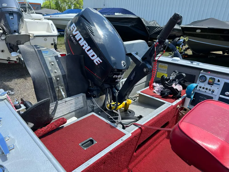 Slide: The Image of 1995 Lund 1660 Pro V Tiller boat with Evinrude motor, red interior, and control panel. - 16